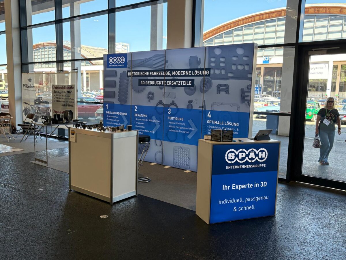 Ein Infostand mit der Aufschrift „Ihr Experte in 3D“ bietet individuelle und passgenaue Lösungen für die Nachfertigung von Fahrzeugteilen an.