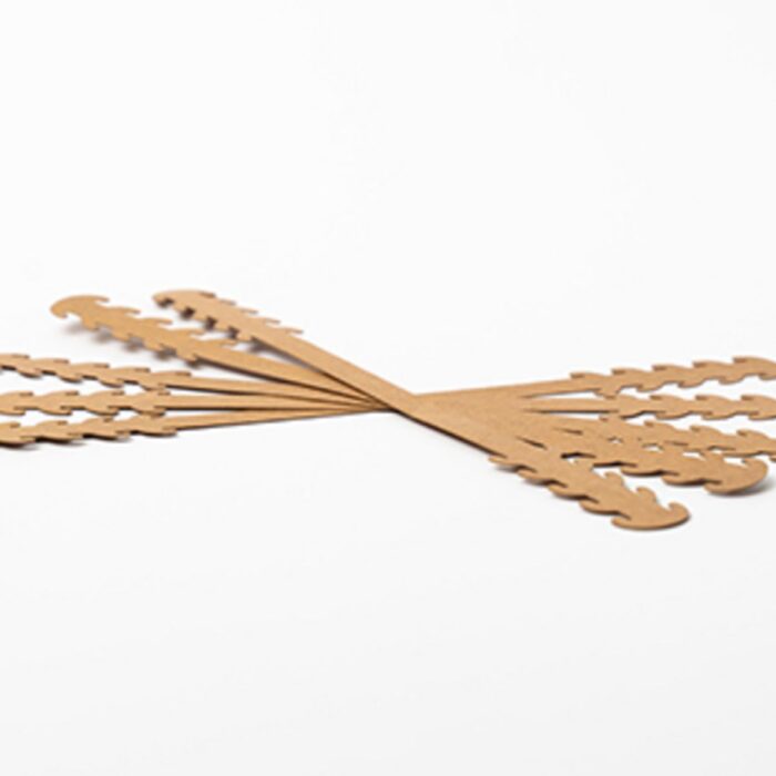 Mehrere beige Kunststoffstreifen, die als verstellbare Halter für Schutzmasken dienen, sind fächerförmig ausgelegt.