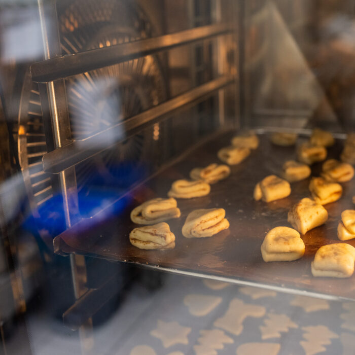 Zwei volle Backbleche mit Weihnachtsgebäck werden im Ofen gebacken.